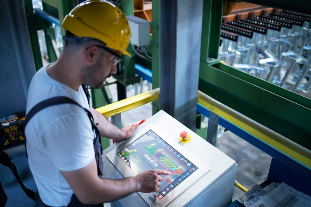 pracownik fabryki zdalny monitoring maszyn przemyslowych i produkcji w sterowni